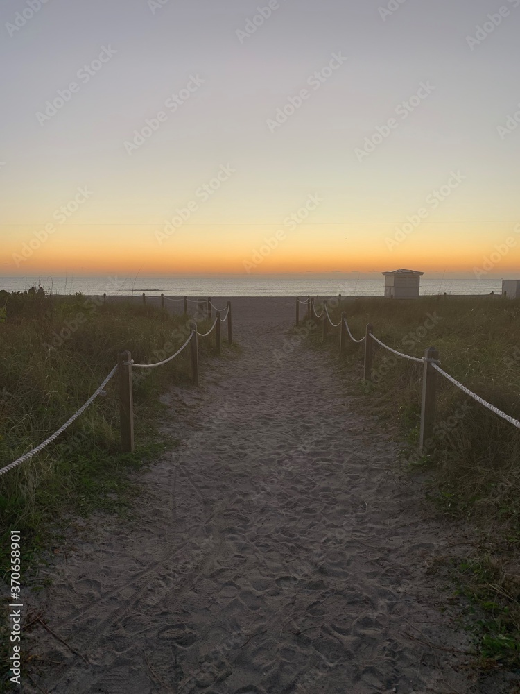 Sandy walkway leading to tricolor beach sunset