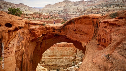 Person standing on Cassidy Arch in Capitol Reef National Park, Utah, United States photo