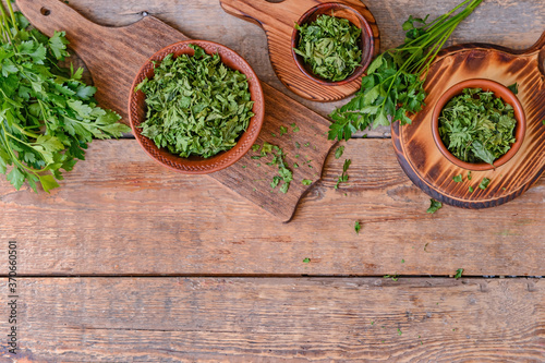 Bowls with dry and fresh parsley on table