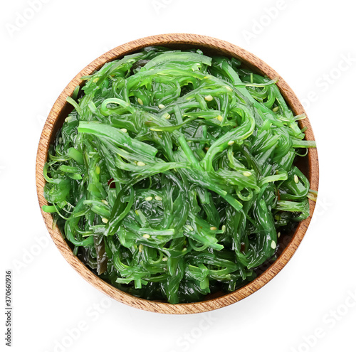 Bowl with tasty seaweed salad on white background