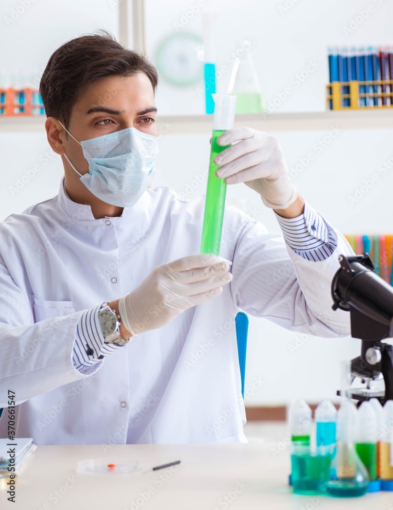 Young chemist student working in lab on chemicals Young chemist student working in lab on chemicals