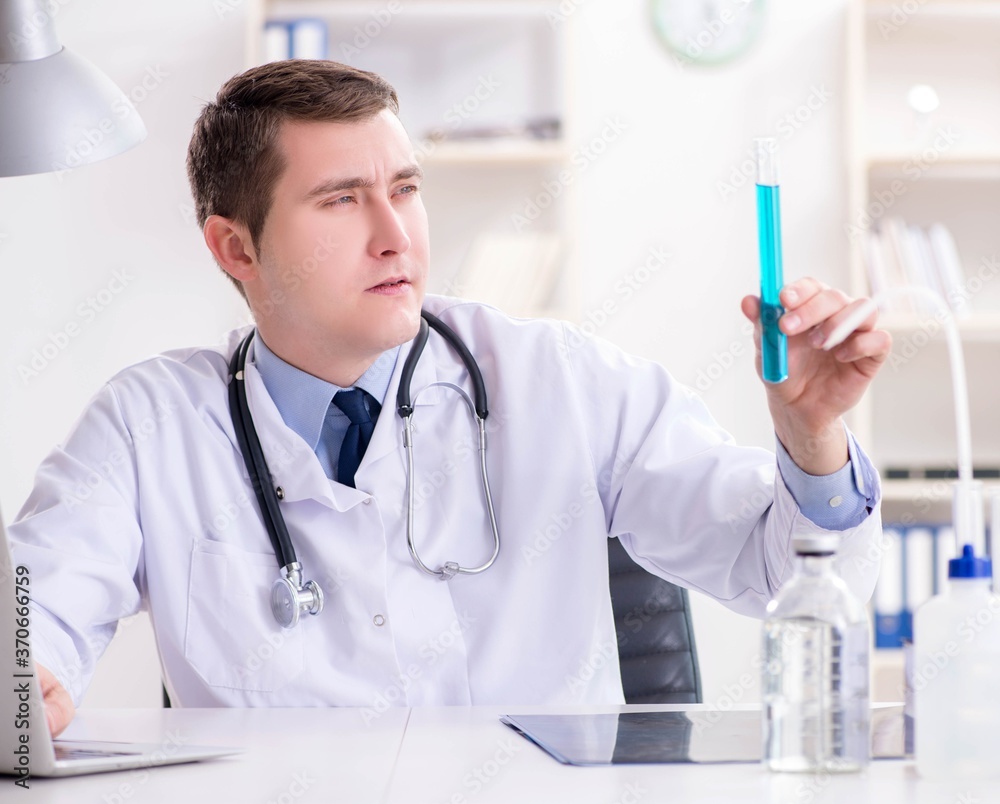 Male doctor looking at lab results in hospital Male doctor looking at lab results in hospital