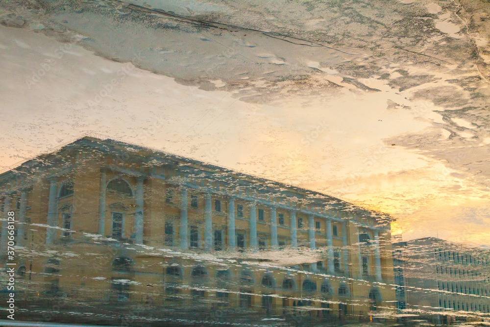 Vintage classical building reflected in freezing Fontanka river