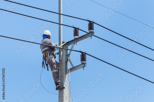 Electricians Wiring Cable repair services,worker in crane truck bucket fixes high voltage power transmission line,setting up the power line wire on electric power pole.