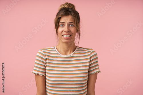 Valokuva Studio photo of young green-eyed brunette female showing her teeth while grimaci