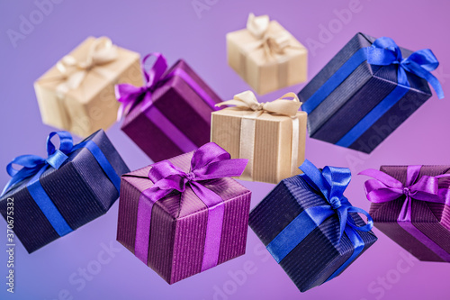 Surprise in flying boxes, wrapped in colored gift paper with bow on bright background. Holidays and greeting card concept.