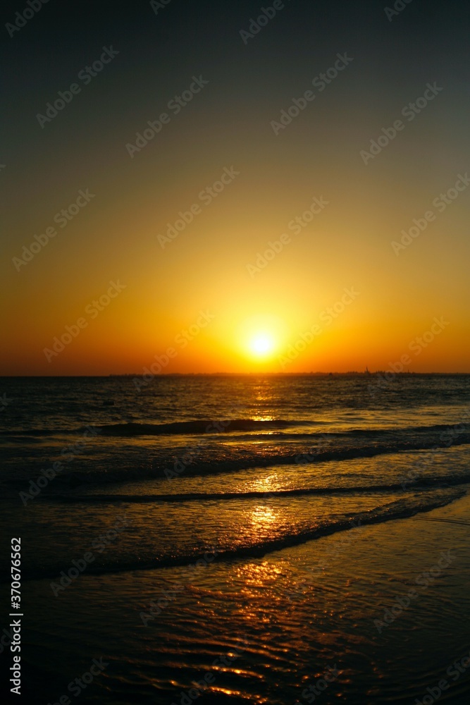 Sunset at the beach with waves and gradient the sky on the beach