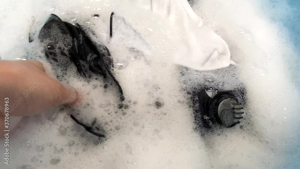 Top view of woman washing many cotton face mask in blue basin. Top view of woman washing many cotton face mask in blue basin.