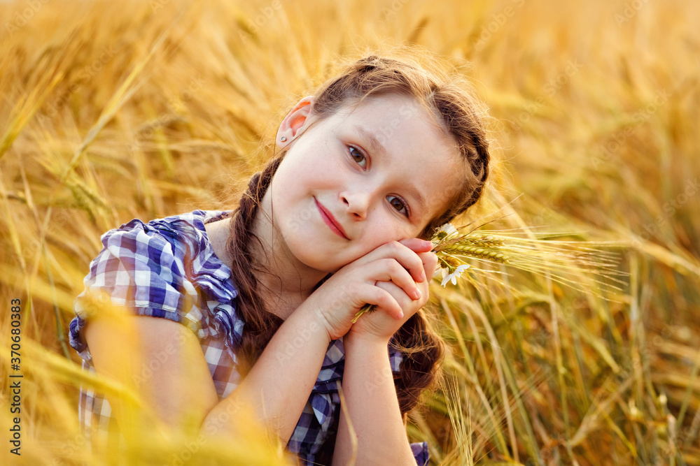 Portrait of a smiling cute little girl in a wheat field in the open air. Nature in the village. Portrait of a smiling cute little girl in a wheat field in the open air. Nature in the village.