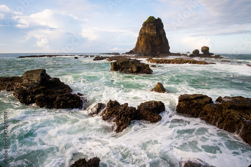 beauty landscape of white sands malikan beach ambulu jember indonesia, the unique rock formation and giant waves photo