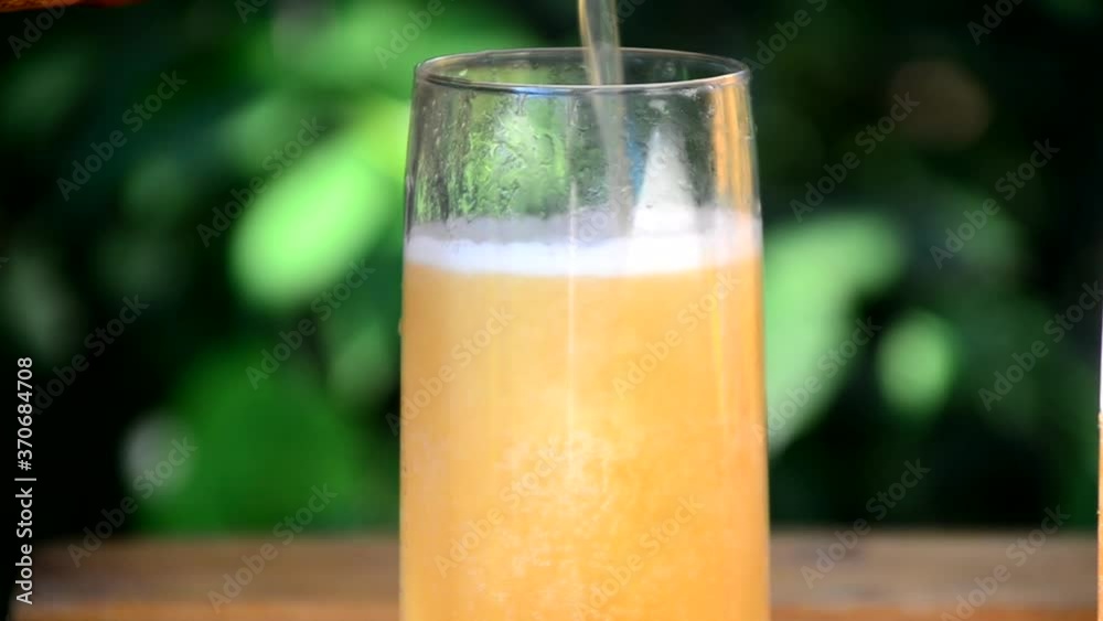 Beer pouring into mug on a table in a cafe or picnic, meeting with friends in nature Beer pouring into mug on a table in a cafe or picnic, meeting with friends in nature