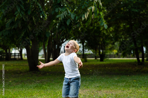 Sad young boy crying and run in nature, park, outdoor. Annoyance and sadness. Looking for support