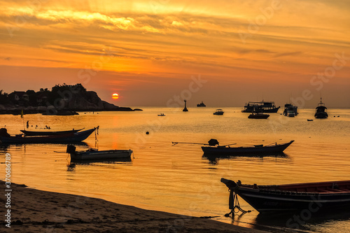 thailand beach sunset with boats and people