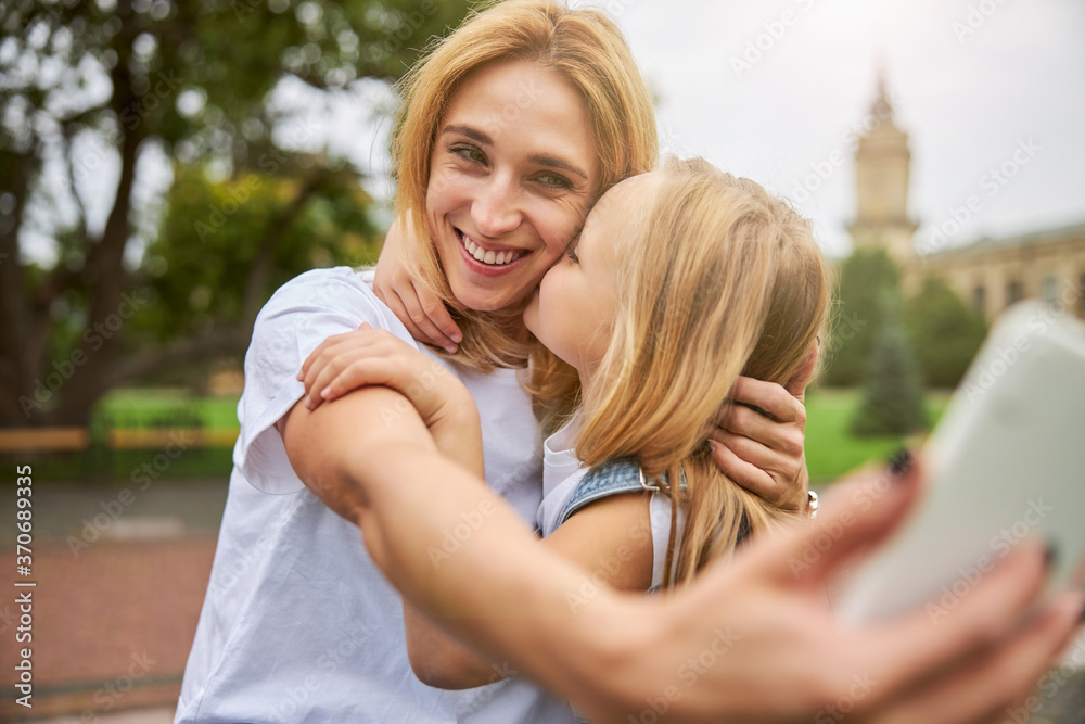 Smiling mother with female child doing selfie on the mobile Smiling mother with female child doing selfie on the mobile