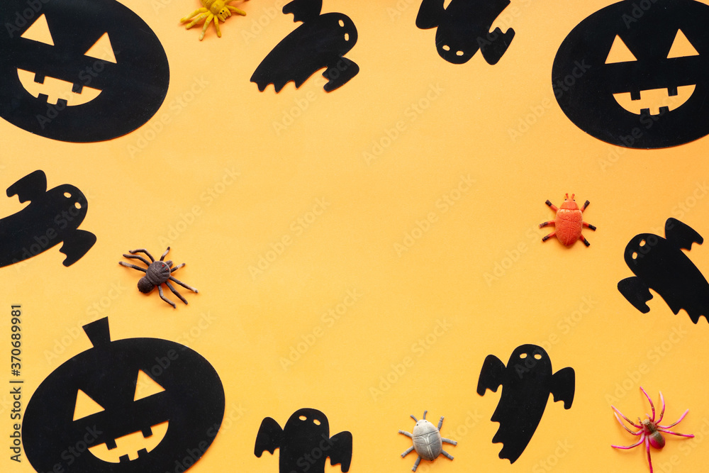 Flat lay Halloween background with decorative pumpkin, spiders and ghost on orange backdrop. Copy space for text. Festive concept.
