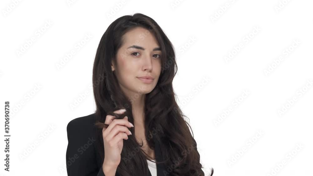 Portrait of young Caucasian woman in formal jacket twirling her hair around finger. Isolated on white background Portrait of young Caucasian woman in formal jacket twirling her hair around finger. Isolated on white background