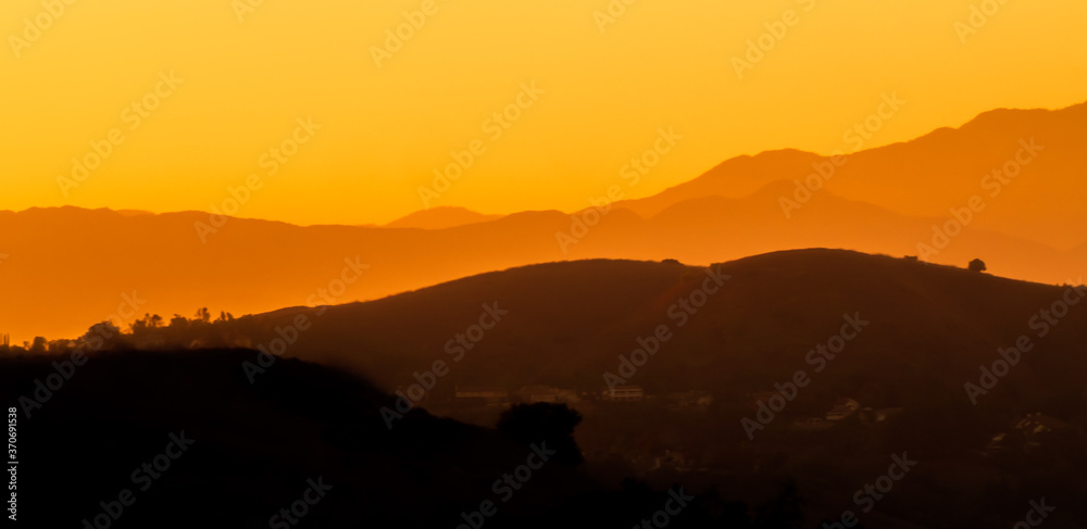 Orange Sky and Haze with Layered Mountains in the Background