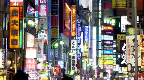 SHINJUKU, TOKYO, JAPAN : View of street and sign (billboard and neon) at Kabukicho downtown area at night. All the logo are blurred or overwritten for this video. Japanese nightlife concept shot. photo