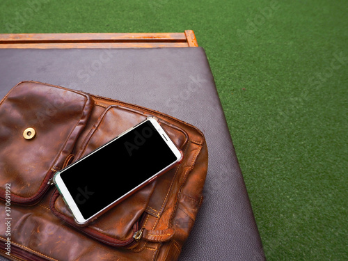smartphone and bag on chair by the pool.
