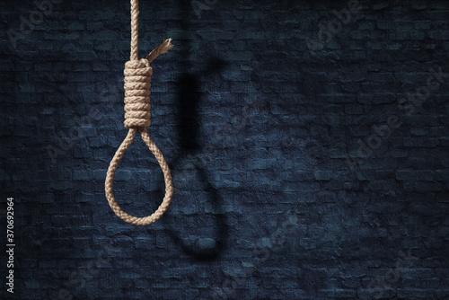 suicide concept. noose with shadow on dark wall background