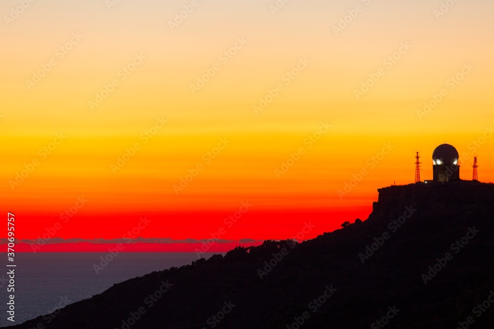 A beautiful sunset over calm Mediterranean waters at Dingli Cliffs in Malta