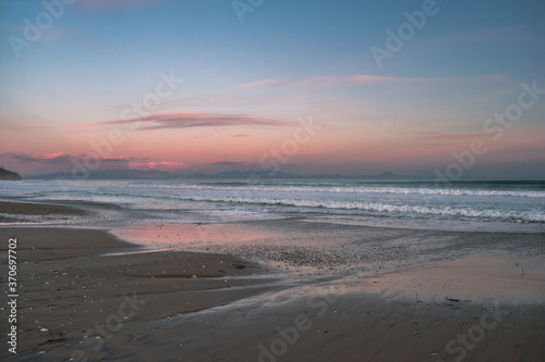 Sea with waves  sea foam and sandy beach at dusk