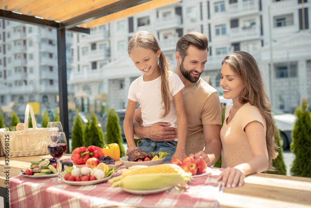 Young cute family having dinner outside and looking happy Young cute family having dinner outside and looking happy