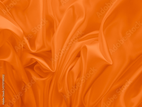 Beautiful elegant wavy orange satin silk luxury cloth fabric texture, abstract background design. 
