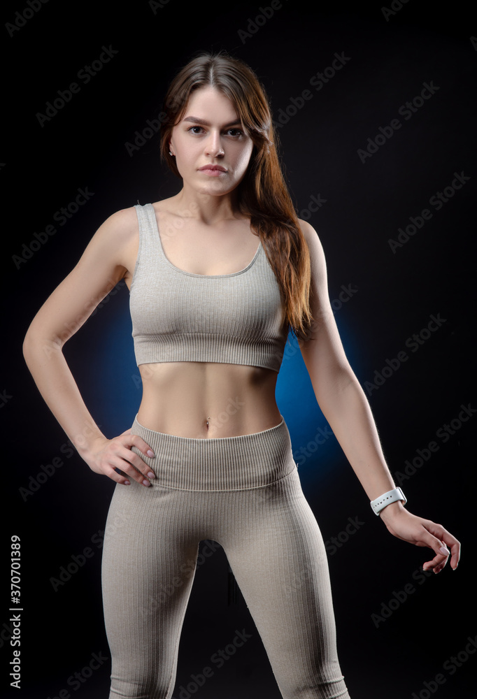 Girl in sports gray uniform on a dark background Girl in sports gray uniform on a dark background