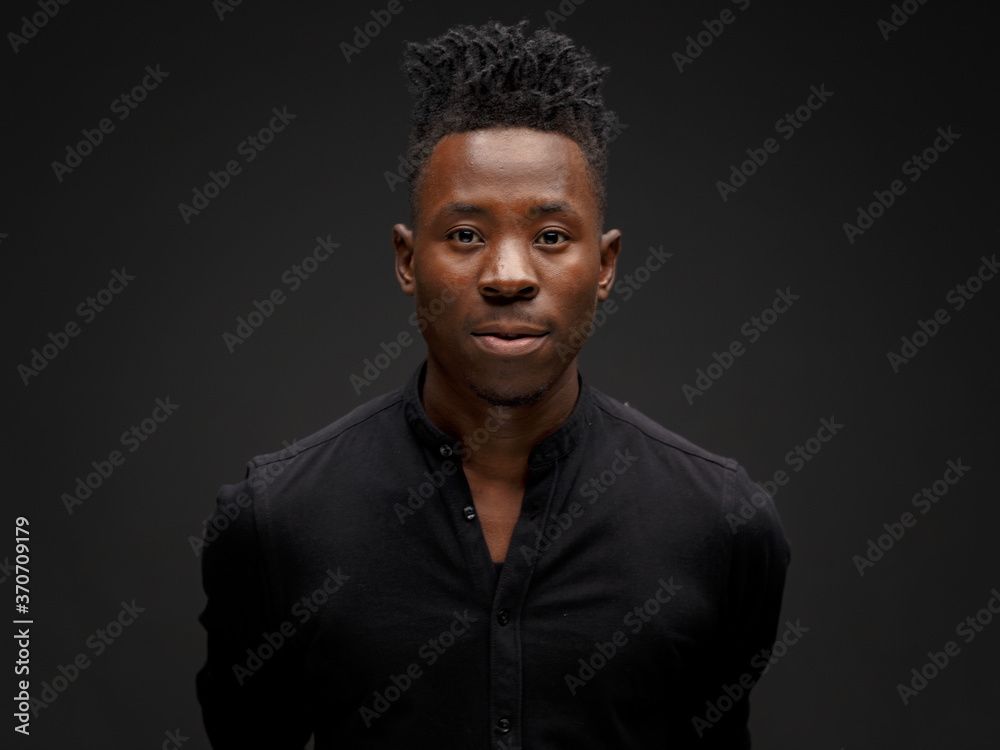 portrait of an African young man in a black shirt on a black background portrait of an African young man in a black shirt on a black background