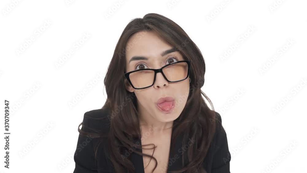 Young Caucasian woman in glasses fooling around in front of camera, sticking her tongue out. Playful mood. Isolated on white background Young Caucasian woman in glasses fooling around in front of camera, sticking her tongue out. Playful mood. Isolated on white background