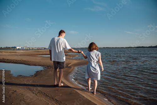 Couple in love on the beach.Young man and woman walking on seashore and laughing.