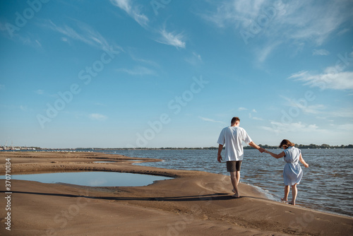 Couple in love on the beach.Young man and woman walking on seashore and laughing. photo