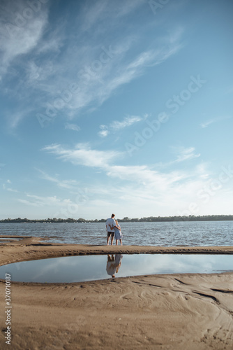 Couple in love on the beach.Young man and woman walking on seashore and laughing. photo