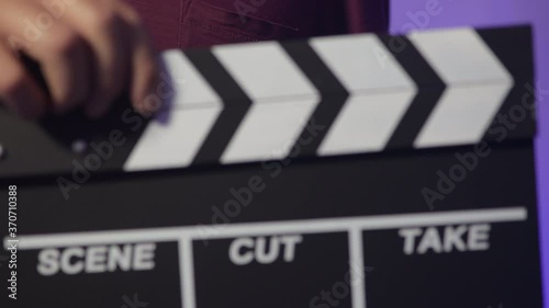 Clapboard on set. Director says action! and the clapboard close down. Cinema or photoshoot concept. Hollywood set with blue background. Close up shot photo