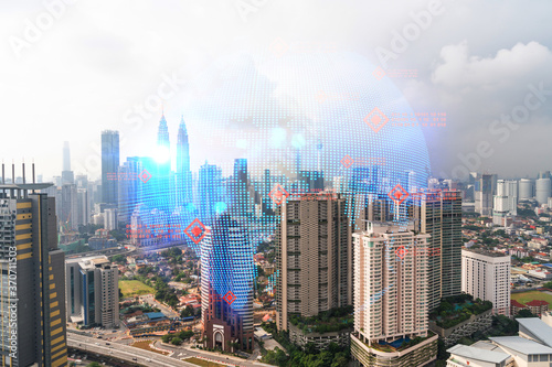 World planet Earth map hologram over panorama city view of Kuala Lumpur, Malaysia, Asia. The concept of international connections and business. Multi Exposure.