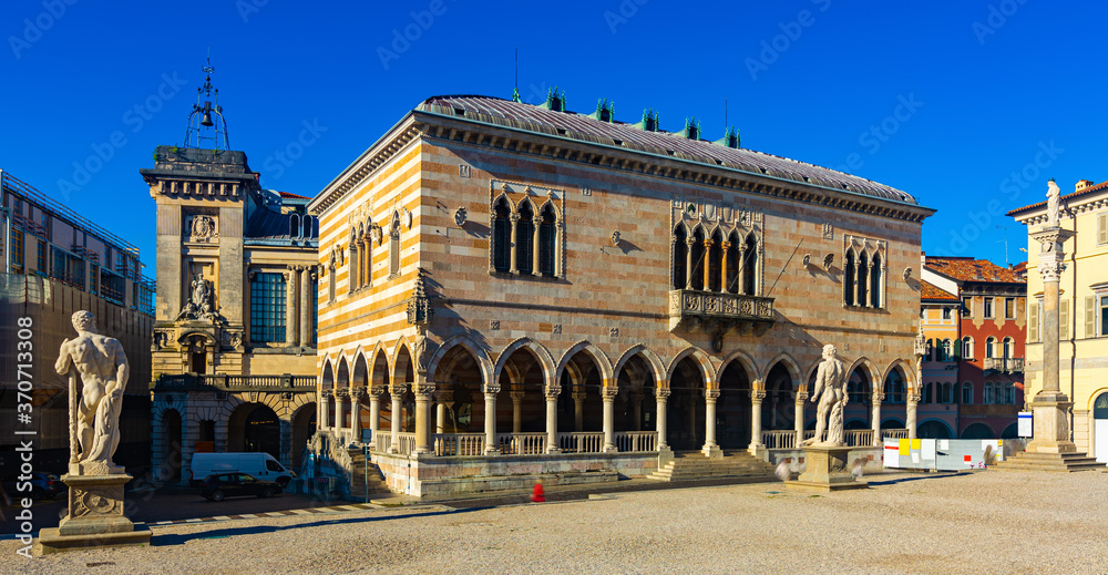 View of Gothic building of Loggia del Lionello - town hall of Udine on central city square of Piazza liberta in sunny day, Italy