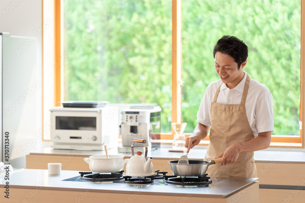 キッチンで料理を作る男性 キッチンで料理を作る男性