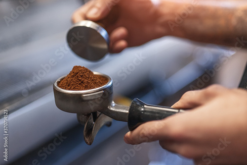 Barista with portafilter preparing coffee