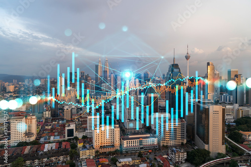 Photography Glowing FOREX graph hologram, aerial panoramic cityscape of Kuala Lumpur at sunset