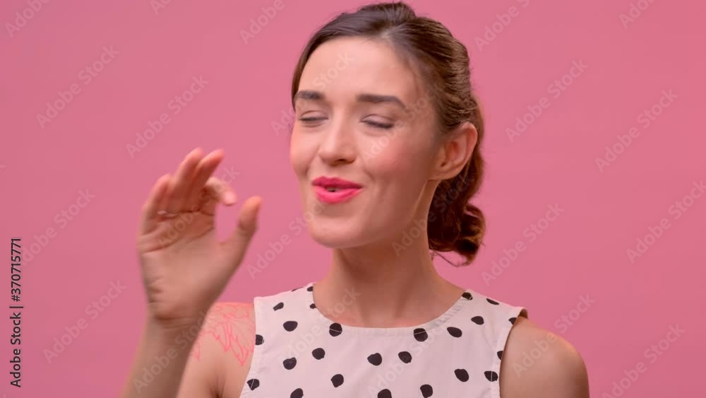 Portrait of happy smiling young woman with dark hair in casual clothes showing ok gesture or zero hand sign on pink background. Positive female smiles to camera. Concept of gestures and body language. Portrait of happy smiling young woman with dark hair in casual clothes showing ok gesture or zero hand sign on pink background. Positive female smiles to camera. Concept of gestures and body language.