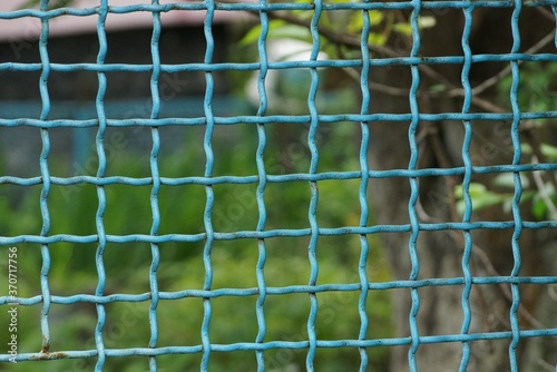 blue metal texture from part of iron mesh in the wall of the fence on the street