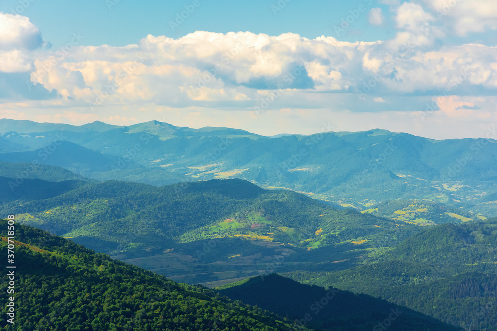 Obraz premium mountain landscape on a summer day. hills rolling from the valley up in to the distant ridge. view of the wonderful outdoor scenery beneath a sky with clouds
