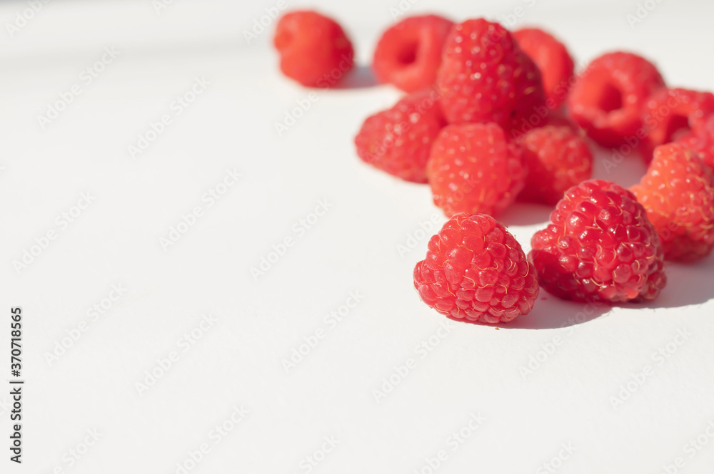 Raspberries on a white plate and with mint in the middle.
Raspberries on a white plate and with mint in the middle.