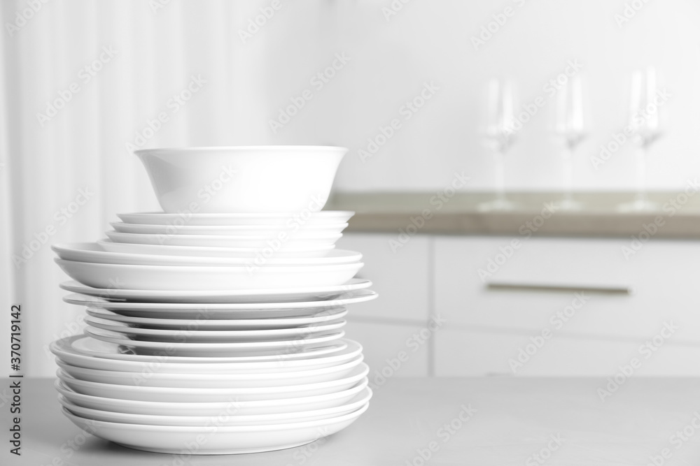 Stack of clean plates on grey table in kitchen. Space for text Stack of clean plates on grey table in kitchen. Space for text