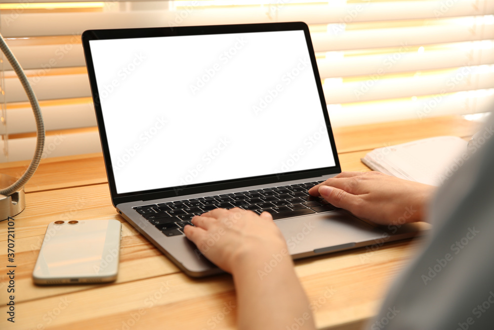 Woman working with modern laptop at wooden table, closeup. Space for design Woman working with modern laptop at wooden table, closeup. Space for design
