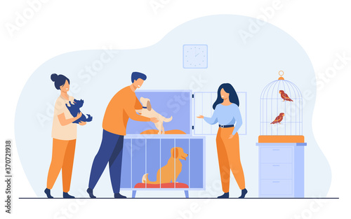 Pet store or animal shelter concept. Man taking puppy from cage, buying or adopting dog. Volunteers helping to choose homeless animal for adoption