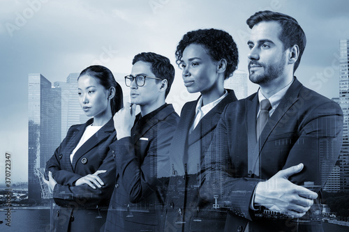 Photography Four successful business consultants standing in a row in suits and ready to tackle with customer problem