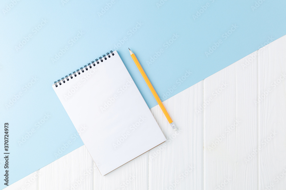 Spiral notepad with pencil on blue background. Spiral notepad with pencil on blue background.