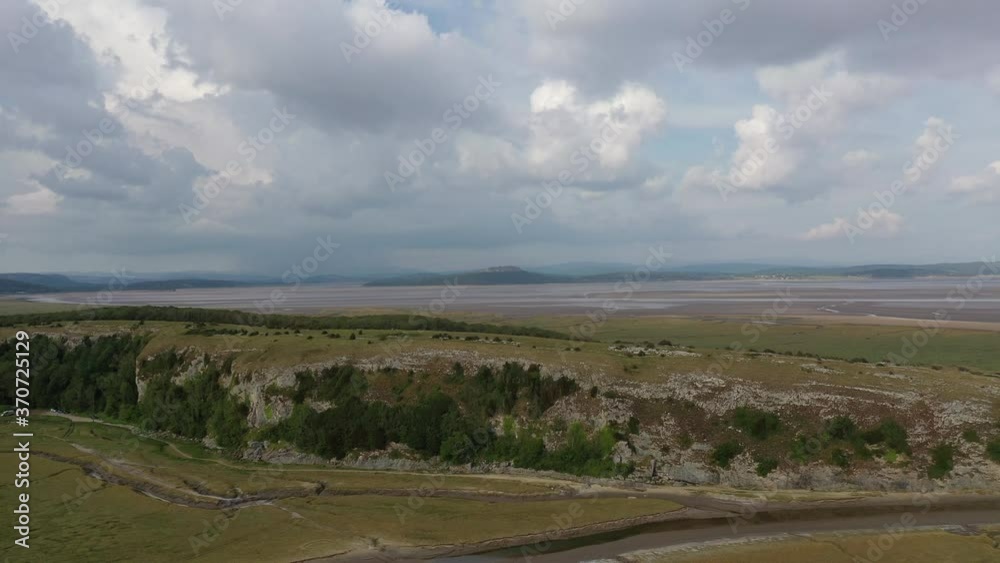 Aerial lowering shot showing a hill located in a coastal bay, on a bright sunny day. Aerial lowering shot showing a hill located in a coastal bay, on a bright sunny day.